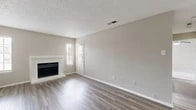 Located at 951 Turner Rd in Grapevine, Texas, this single-story, 2-bedroom, 1-bathroom home offers a practical and comfortable layout with clean, neutral finishes throughout. The living room serves as the heart of the home, featuring durable wood-look vinyl plank flooring, a white-framed fireplace, and multiple windows that allow natural light to fill the space. A textured ceiling adds a classic touch, while the open entry area provides a welcoming transition into the main living space. The kitchen is equipped with white cabinetry, light stone-finish countertops, a white electric range with overhead ventilation, and an adjacent utility/laundry closet, making efficient use of the available space. Both bedrooms are finished with plush carpeting and feature windows with blinds that offer views of the surrounding greenery. The primary bedroom includes a closet with bifold doors, providing organized storage. The full bathroom is outfitted with a white tiled shower-tub combination and standard fixtures. Throughout the home, a consistent warm beige color palette creates a cohesive and neutral ambiance, offering a versatile canvas for personalization. The single-floor design ensures easy accessibility and a straightforward flow between all rooms.