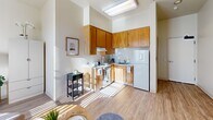 Located at 17305 Monterey St in Morgan Hill, CA, this efficiently designed single-floor studio combines a kitchen and living area into one cohesive space, complemented by a full bathroom. Light wood-style flooring runs throughout, creating a clean, warm aesthetic that unifies the layout.

The combined kitchen and living area is bright and open, benefiting from a large window dressed with vertical blinds that allows natural light to fill the room. A ceiling fan overhead aids in air circulation and comfort. The living area provides a functional and inviting atmosphere, while the kitchen is tucked neatly into a corner, featuring warm wood cabinetry extending to the upper walls, light countertops, a stainless steel sink, an electric range, and a full-size refrigerator — all well-appointed for everyday cooking needs. A skylight above the kitchen adds an extra touch of brightness.

The bathroom offers a practical and tidy layout with warm wood cabinetry beneath a single vanity sink, a wall-mounted mirror, overhead lighting, and a glass-door shower enclosure. Wood-style flooring continues into this space, maintaining a consistent look throughout the unit.

Overall, the space presents a bright, neutral palette with cream-toned walls and warm wood accents, making it a cozy and functional residence in the heart of Morgan Hill.