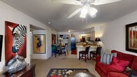 This single-floor, 2-bedroom, 1-bathroom residence offers a practical and comfortable layout designed for everyday living. The open-concept living and dining area serves as the heart of the home, featuring carpet flooring, a ceiling fan with light fixture, and a textured ceiling. The living room provides generous space for seating and entertainment, with a window that brings in natural light. It connects seamlessly to the dining area and kitchen, creating an inviting flow throughout.

The kitchen is equipped with black appliances, including a refrigerator, stove, and built-in microwave, complemented by light wood cabinetry and a wraparound countertop. A curved breakfast bar with bar seating adds a casual dining option and visually anchors the open-plan space. Adjacent to the kitchen is a dedicated laundry area with in-unit washer and dryer hookups.

The primary bedroom is a well-proportioned retreat featuring carpet flooring, a ceiling fan, and a window for natural light. The second bedroom offers similar features, providing comfortable accommodations. The full bathroom includes a single-sink vanity with light wood cabinetry, a large mirror, a tub-shower combination, and tile flooring. A hallway connects the private areas of the home to the main living spaces, completing this efficiently designed residence.