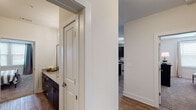 This thoughtfully designed single-floor residence offers a cohesive blend of modern aesthetics and functional living. The kitchen serves as a focal point, featuring dark cabinetry with brushed nickel hardware, granite countertops, stainless steel appliances, and a central island with seating — all illuminated by stylish pendant lighting and wood-look flooring. An adjacent dining area benefits from natural light streaming through a glass-paneled entry door and surrounding windows, creating a bright and welcoming atmosphere. The living room is generously proportioned, with large windows dressed in sheer curtains and wood blinds that fill the space with natural light. A secondary room functions seamlessly as both a lounge and home office, complete with floating shelves and ample natural light. The primary bedroom is a serene retreat with plush carpeting, a ceiling fan, and direct access to an en suite bathroom featuring dark vanity cabinetry and granite countertops. Additional bedrooms share similarly refined finishes and soft carpeting. Bathrooms throughout maintain a consistent, polished design with granite vanities and wood-look flooring. A spacious walk-in closet with wire shelving and carpet completes the primary suite. The overall ambiance is contemporary and inviting, with neutral tones and quality finishes tying each room together cohesively.