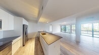 Located at 4400 West Sunrise Boulevard in Plantation, FL, this modern 2-bedroom, 2-bathroom residence offers a thoughtfully designed open-concept layout across a single floor. Light wood-tone flooring flows seamlessly throughout, complementing the clean, contemporary aesthetic of bright white walls and crisp finishes.

The kitchen and living area form a cohesive, open space at the heart of the home. The kitchen is equipped with stainless steel appliances, including a French door refrigerator, electric range, and over-the-range microwave. Sleek white cabinetry extends to the ceiling, maximizing storage, while dark veined stone countertops and a gold-toned undermount sink add a refined touch. A subway tile backsplash completes the polished look.

The living room is bathed in natural light from large sliding glass doors that open to a private balcony overlooking lush tropical landscaping. Both bedrooms are well-proportioned, with the primary bedroom offering generous square footage and its own balcony access. The two bathrooms are finished with large-format marble-look tile flooring, glass-enclosed showers, floating vanities with dark stone countertops, and modern fixtures. A dedicated closet and hallway round out the functional layout of this well-appointed Plantation residence.