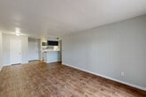 Located at 6601 Dunlap St in Houston, TX, this single-story, one-bedroom, one-bathroom unit offers a practical and well-organized layout across a comfortable footprint. Rich wood-look flooring runs throughout the main living areas, lending warmth and visual continuity to the space.

The open living and dining area is bright and spacious, with neutral gray walls and clean white baseboards. A peninsula-style kitchen connects seamlessly to the main living space, featuring dark upper cabinetry, a bold overhead range hood, white appliances including a range and refrigerator, and a white countertop that also serves as a breakfast bar. A pantry provides additional storage adjacent to the kitchen.

The bedroom is carpeted for comfort and is equipped with a ceiling fan and a window that brings in natural light. A sliding glass door opens to an outdoor area, offering an easy indoor-outdoor connection. The bedroom benefits from generous closet space, including a walk-in closet with dual hanging rods and built-in shelving.

The bathroom features a full tub-shower combo with white tile surround, a dark vanity with a marble-look countertop, and wood-look flooring. A dedicated laundry area adds everyday convenience. The hallway connects all rooms efficiently, completing the functional and cohesive floor plan.
