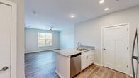 Located at 2331 Cadotte Dr SW in Wyoming, MI, this well-appointed 1-bedroom, 1-bathroom unit offers a thoughtfully designed single-floor layout. The open-concept living and kitchen area is anchored by a peninsula with granite countertops, an undermount sink, and a stainless steel appliance suite including a refrigerator, range, microwave, and dishwasher. White shaker-style cabinetry provides generous storage, while recessed lighting brightens the space. Wood-look luxury vinyl plank flooring extends throughout the main living areas, complemented by a ceiling fan and multiple windows fitted with horizontal blinds that allow ample natural light and outdoor views. The bedroom features plush carpeting, a large window with outdoor views, and access to ample closet space — four closets are distributed throughout the unit, offering exceptional storage. The bathroom is finished with a white vanity, granite countertop, a large mirror, and wood-look flooring, maintaining the consistent modern aesthetic found throughout. A dedicated in-unit laundry area adds everyday convenience. Neutral gray tones on the walls throughout create a clean, contemporary ambiance suited for comfortable living.