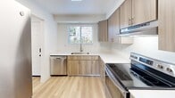 Located in Vancouver, WA, this two-story, 2-bedroom, 1-bathroom home is thoughtfully laid out across two floors. The main level features a bright, open living room with light hardwood flooring and a sliding glass door that invites abundant natural light and outdoor views. The adjacent kitchen is well-appointed with contemporary wood-tone cabinetry, crisp white countertops, stainless steel appliances including a dishwasher and electric range, and a window overlooking the outdoors. A dedicated laundry room on this level includes a full-size GE washer and dryer with overhead shelving for added storage convenience. Upstairs, the two bedrooms offer plush carpeting and clean white walls. The spacious primary bedroom provides ample room to relax, while the second bedroom features a large window with pleasant exterior views. A well-sized closet with built-in shelving and hanging rods provides organized storage. The bathroom is clean and functional, finished with light hardwood floors and brushed gold hardware accents. Throughout the home, a neutral color palette and bright, airy atmosphere create a welcoming and versatile living environment.