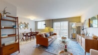 Located at 2746 Belmont Ave in Philadelphia's 19131 neighborhood, this one-bedroom, one-bathroom residence offers a thoughtfully designed single-floor layout. The open-plan living and dining area is the heart of the home, filled with natural light streaming through large sliding glass doors fitted with vertical blinds. The living space features warm, neutral-toned carpeting and accent walls in earthy greens and yellows, lending the area a welcoming ambiance. A dedicated dining nook sits adjacent to the living room, adorned with a geometric diamond mirror arrangement and a window offering outdoor views. The kitchen is outfitted with light maple cabinetry, dark granite-style countertops, hardwood-style flooring, and full appliances including a gas range and built-in microwave, providing ample storage and prep space. The generously sized primary bedroom accommodates a full furniture suite with ease, features plush carpeting, a bright window with outdoor views, and a mid-century modern aesthetic. The bathroom maintains a clean, bright design with tile flooring, a shower-tub combination, and built-in shelving. A hallway connects all rooms efficiently, completing this cohesive and comfortable residence.
