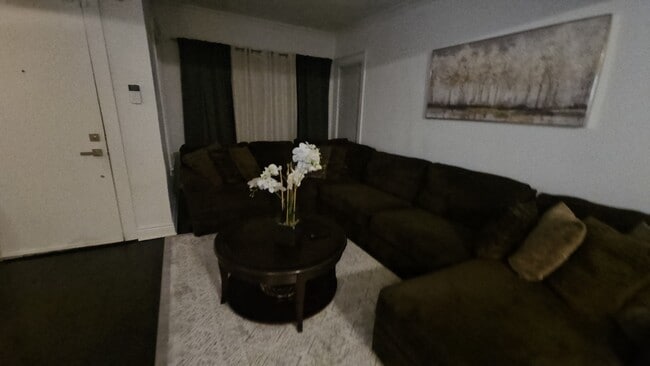 Amplia sala de estar con cómodo sofá y televisor inteligente de 70 pulgadas. - 7914 S Ridgeland Ave