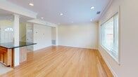 Located at 20 Thornton Road in Brookline, MA, this two-floor unit offers a thoughtfully organized layout across its main and upper levels. The main floor, which comprises the larger share of the total living space, features an open living room with warm hardwood flooring, recessed lighting, crown molding, and a generously sized window that frames views of the surrounding neighborhood. The kitchen is well-appointed with warm-toned wood cabinetry, dark granite countertops, tile flooring, and a full suite of stainless steel appliances including a gas range, microwave, refrigerator, and dishwasher. Natural light filters into the kitchen through a window above the sink, enhancing the functional workspace.

A staircase connects the main floor to the upper level, where the primary bedroom is situated. The bedroom is a comfortable, well-proportioned room featuring hardwood floors, crown molding, a window providing natural light and neighborhood views, and a built-in closet with integrated shelving and drawers for ample storage. The full bathroom features white tile flooring, a vanity with a marble-style countertop, and a window that allows natural light into the space.