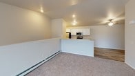 Located at 6905 Schofield Ave in Weston, Wisconsin, this single-floor unit offers a well-organized and functional layout. The open living area is bright and welcoming, featuring plush carpeting, baseboard heating, a wall-mounted air conditioning unit, and a sliding glass door that lets in natural light and provides outdoor access. A half-wall partition separates the living space from the kitchen, which is outfitted with white cabinetry, granite-look countertops, stainless steel appliances including a refrigerator, range, microwave, and dishwasher, and durable wood-look vinyl flooring. The bedrooms are carpeted and generously sized, with ample natural light from windows. One bedroom features a walk-in closet with built-in shelving and wood-look flooring. The unit includes two bathrooms: one with a walk-in shower, wood-look vinyl flooring, white cabinetry, and a granite-top vanity, and a second with a tub-shower combination, matching white cabinetry, granite-top vanity, and a wall-mounted storage cabinet. Throughout the unit, a neutral color palette of whites and soft grays creates a clean, move-in-ready atmosphere.