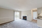 Located at 2 Observation Court in Germantown, Maryland, this well-appointed two-bedroom, two-bathroom residence offers a comfortable and functional layout across a single floor. The open living and dining area is highlighted by crown molding, a wood-burning fireplace, and sliding glass doors that lead to a private balcony with outdoor views — allowing natural light to fill the space. Neutral-toned walls and soft carpeting throughout the living areas and bedrooms create a warm, cohesive ambiance. The kitchen features granite countertops, white cabinetry, stainless steel appliances, and light hardwood-style flooring, with a breakfast bar that connects seamlessly to the main living area. Both bedrooms are generously proportioned with plush carpet and windows that bring in natural light; the primary bedroom offers a comfortable, private retreat. The two bathrooms each include a full tub-shower combination with white tile surround. A dedicated laundry room houses a full-size side-by-side washer and dryer, adding everyday convenience. A closet provides additional storage. The consistent use of chair rail molding and textured ceilings throughout ties the design together with a classic residential character.
