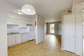 Located at 1717 College St in Houston, TX, this one-bedroom, one-bathroom unit offers a practical and well-organized single-floor layout. The open-concept design connects the kitchen, dining, and living areas into one cohesive space, brightened by a window near the front entry that allows natural light to filter through. A painted brick accent wall separates the kitchen from the living area, adding a subtle architectural detail to the interior.

The kitchen is well-equipped with white cabinetry extending to the ceiling for ample storage, light-toned countertops, a stainless steel double sink, a full suite of white appliances including a coil-top range, dishwasher, and refrigerator, and a window providing additional ventilation and light. The living room features a textured ceiling and a built-in shelving unit with cabinet storage below, offering both display and functional storage space.

The bedroom is a comfortable size, featuring a ceiling fan, a textured ceiling, and two closets — including a spacious walk-in with multi-level shelving and hanging rods. The full bathroom is bright and clean, with a wide vanity, large mirror, and a bathtub with a frosted window above. Tile flooring runs consistently throughout the entire unit, contributing to a cohesive and easy-to-maintain interior.