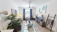 Located at 206 E Mitchell St in Arlington, Texas, this single-floor unit offers a well-designed layout with modern finishes throughout. The living room serves as the heart of the space, featuring wood-look flooring, a ceiling fan, and a large window dressed with teal curtains that invite an abundance of natural light. The room comfortably accommodates a full seating arrangement, complete with a sofa, accent chair, and media console.

The kitchen is equipped with stainless steel appliances, including a refrigerator, range, and microwave, complemented by two-tone cabinetry — crisp white upper cabinets paired with dark lower cabinets — and light countertops. A dining table adjacent to the kitchen provides a dedicated space for meals.

The unit includes two bedrooms, each with ceiling fans, wood-look flooring, and access to closet space. One bedroom features a walk-in closet, adding practical storage. Both bathrooms are outfitted with a tub-shower combination, a single vanity with a white countertop, and dark wood-toned cabinetry, maintaining a consistent, contemporary aesthetic throughout the home. The overall design is clean and functional, making this an informative and well-appointed residential space.