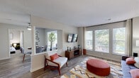 Located in Norcross, Georgia, this 2-bedroom, 2-bathroom residence offers a thoughtfully designed single-floor layout with modern finishes throughout. Wood-style flooring flows through the main living areas, creating a cohesive and contemporary look. The open living room is bathed in natural light from large windows overlooking outdoor greenery, and connects seamlessly to the dining area through a half-wall pass-through column — an architectural detail that adds character while maintaining an open feel. The kitchen features white shaker cabinetry, white subway tile backsplash, light countertops, and stainless steel appliances including a gas range and refrigerator. A dedicated dining room with a ceiling fan sits adjacent to the kitchen, ideal for everyday meals or entertaining. Both bedrooms are carpeted and generously sized, with the primary bedroom offering a walk-in closet and a large window that fills the room with natural light. The two bathrooms are clean and functional, each with white vanities, quartz-style countertops, and tub-shower combinations. A dedicated laundry room with full-size washer and dryer hookups adds everyday convenience. Neutral tones and textured ceilings give the space a comfortable, move-in-ready ambiance throughout.