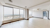 Located in the heart of downtown Dallas on Elm Street, this sophisticated high-rise residence offers a single-level layout with 2 bedrooms and 6 bathrooms. Floor-to-ceiling windows throughout flood the space with natural light and frame stunning panoramic views of the Dallas skyline and cityscape beyond.

The open-concept kitchen and living area is anchored by a striking island with a marble-look stone countertop, complemented by warm wood cabinetry, stainless steel appliances, and light hardwood flooring that flows seamlessly into the living area. The living room features a ceiling fan, crown molding, and a built-in beverage station, adding a refined touch.

The generously sized primary bedroom features plush carpeting, a ceiling fan, and expansive floor-to-ceiling windows with sweeping city views. The primary bathroom is a spa-like retreat with marble-look tile, a soaking tub, glass-enclosed shower, and remarkable skyline views. Both bedrooms are served by dedicated closets with custom shelving and built-in hanging rods.

Additional highlights include a dedicated laundry room with side-by-side washer and dryer, light tile flooring, and ample storage above. A connecting hallway ties all rooms together in a functional and cohesive layout, making this a refined urban residence in one of Dallas's most sought-after locations.