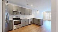 Located at 601 Press Pl in Nashville, TN, this well-designed one-bedroom unit offers a thoughtfully laid-out single-floor plan that maximizes every square foot. Warm hardwood-style flooring runs consistently throughout the space, lending a cohesive and inviting feel.

The kitchen and living area form an open, combined space at the heart of the unit. The kitchen is outfitted with gray shaker-style cabinetry, a white subway tile backsplash, stainless steel appliances — including a French door refrigerator, range, microwave, and dishwasher — and a white quartz peninsula countertop with pendant lighting overhead. Recessed lighting provides bright, even illumination throughout.

The bedroom offers a comfortable, private retreat with a ceiling fan, large windows fitted with blinds that invite natural light and urban views of the surrounding Nashville neighborhood. An additional windowed area and a sliding glass door further enhance the sense of openness.

A dedicated walk-in closet serves the bedroom with a custom organization system featuring shelving, hanging rods, and built-in drawers — providing ample, well-structured storage. The clean white walls and neutral color palette throughout the unit create a bright, modern ambiance well-suited to urban living in the heart of Nashville.