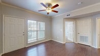 Located at 3963 Allison Ln in Johnson, Arkansas, this single-story residence offers a well-organized layout designed for comfortable everyday living. The main living area features rich hardwood-style flooring, crown molding, and a ceiling fan with light fixture, creating a polished and inviting atmosphere. A large window with horizontal blinds allows natural light to fill the room, while open sightlines connect the living space to the adjacent dining and kitchen areas.

The kitchen is thoughtfully appointed with white cabinetry, light countertops, and a decorative tile backsplash in muted green and gray tones. Black appliances — including a refrigerator, electric range, dishwasher, and over-range microwave — provide a cohesive, functional workspace. Hardwood-style flooring continues throughout the kitchen.

The bedroom offers plush carpeting, a ceiling fan, and a dedicated walk-in closet with built-in shelving for organized storage. The bathroom includes a single-sink vanity with light countertops, overhead cabinetry, and a full tub-shower combination, with hardwood-style flooring extending through the space.

A separate laundry area accommodates a full-sized washer and dryer, adding convenience to daily routines. Overall, the residence presents a clean, neutral palette throughout.