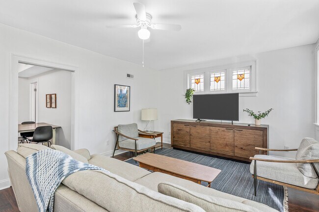 Bright living room with large window bay and stained glass windows. - 3441 Shenandoah Ave