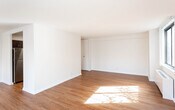 Located at 380 Prospect Ave in Hackensack, New Jersey, this high-rise unit offers an impressive combination of modern finishes and expansive city views. Warm hardwood flooring flows consistently throughout the living spaces, complementing the clean, neutral-toned walls and creating a bright, cohesive aesthetic.

The open living area is generously proportioned, bathed in natural light through large picture windows that frame sweeping panoramic views of Hackensack and the surrounding region. A radiator unit beneath each window ensures year-round comfort, while the textured ceiling adds a classic architectural touch.

The bedroom mirrors the same hardwood floors and neutral palette, with a sizable window that continues to showcase the impressive elevated cityscape, making it a tranquil and light-filled retreat.

The kitchen is thoughtfully appointed with dark espresso cabinetry, granite countertops, a white subway tile backsplash, and a full suite of stainless steel appliances including a gas range, over-the-range microwave, and refrigerator.

The bathroom is finished with large-format beige wall tiles, classic hexagonal mosaic floor tiles, a soaking tub with shower, and a dark-cabinet vanity topped with granite, offering a clean and refined look. The overall layout, as seen in the dollhouse view, is efficiently designed for comfortable, functional everyday living.