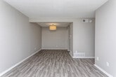 Located at 420 N Dean Rd in Auburn, Alabama, this single-floor unit offers a well-organized layout with consistent, modern finishes throughout. The main living area is generously proportioned, featuring durable wood-style plank flooring in a cool gray tone, neutral painted walls, white baseboards, and a textured ceiling. A central flush-mount light fixture provides even illumination, and built-in floor vents support climate control throughout the space. The entry area welcomes natural light through a window fitted with blinds, creating a bright and inviting atmosphere from the moment you step inside.

The kitchen is outfitted with dark espresso-toned cabinetry, granite countertops with a subtle speckled pattern, an undermount stainless steel sink, and a stainless steel dishwasher. The space is functional and well-appointed, with ample upper and lower cabinet storage. Lighter wood-style flooring continues into this area, complementing the overall design palette.

The bedroom is carpeted in a soft gray tone and includes a standard closet with built-in hanging rods. A window allows natural light to filter in, adding warmth to the room. The full bathroom features the same dark cabinetry and granite vanity found in the kitchen, paired with a tub-shower combination and wood-look tile flooring, maintaining a cohesive aesthetic across the unit.