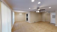 This two-story, 3-bedroom, 3-bathroom home in Baton Rouge, Louisiana offers a well-designed layout with generous living spaces spread across both floors. The main living area is expansive and open, featuring warm neutral tones, plush carpeting, and recessed lighting complemented by ceiling fans. Large windows with vertical blinds allow ample natural light to fill the room, creating a bright and airy atmosphere. A dedicated dining area is distinguished by an elegant chandelier, adding a touch of refinement to the space.

One of the home's most striking architectural features is the spiral staircase, crafted with rich dark wood treads and a metal frame, which connects the two floors with a distinctive visual flair. An open upper-level landing with a wooden balcony railing overlooks the lower level, enhancing the sense of vertical space and volume.

The galley-style kitchen is well-appointed with dark espresso cabinetry, light granite countertops, tile flooring, a double-basin sink, and black appliances including a range and dishwasher. Multiple bathrooms throughout the home feature clean white vanities, wood-look tile flooring, and ample mirror space. The overall design maintains a cohesive, neutral palette, making this Baton Rouge home a versatile and functional residence.