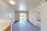 Located at 418 N Second St in Dixon, CA, this single-floor, one-bedroom, one-bathroom unit offers a practical and well-appointed layout. The open-concept living, dining, and kitchen area is anchored by warm hardwood-style flooring and filled with natural light courtesy of a sliding glass door that opens to an outdoor view, creating a bright and welcoming atmosphere throughout.

The kitchen is efficiently designed with oak-toned cabinetry, ample counter space, a stainless steel sink, and white appliances including a refrigerator and range. A peninsula with a breakfast bar connects the kitchen to the dining and living area, while a ceiling fan overhead keeps the space comfortable. The living area is generously proportioned for its scale and benefits from the natural light streaming through the sliding door.

The bedroom is carpeted and bathed in natural light from multiple windows that frame outdoor greenery, lending a calm and serene quality to the room. A dedicated closet provides practical storage. The bathroom features hardwood-style flooring, an oak vanity with countertop storage, and a tiled shower-tub combination. Clean, neutral tones throughout the unit create a cohesive and move-in-ready environment.