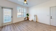 Located at 1340 S 48th St in Mesa, AZ, this well-designed one-bedroom, one-bathroom residence offers a thoughtfully organized layout across a single floor. The open-concept living and kitchen area serves as the heart of the home, showcasing wood-look plank flooring, recessed lighting, and a ceiling fan that enhances airflow and comfort. The kitchen is a standout feature, equipped with crisp white shaker cabinetry, a herringbone tile backsplash, stainless steel appliances including a refrigerator, microwave, and range, and a central island with a quartz-style countertop and pendant lighting overhead — ideal for both meal prep and casual dining. The living area benefits from natural light through large windows fitted with blinds. The bedroom is a comfortable retreat with plush carpeting, a generously sized window, and direct access to a spacious walk-in closet outfitted with dual hanging rods and shelving. The bathroom features a clean, modern aesthetic with white cabinetry, an undermount sink, quartz countertops, black hardware accents, wood-look flooring, and marble-style tile surrounding the tub and shower area. This residence combines contemporary finishes with functional design throughout.
