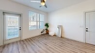 Located at 1340 S 48th St in Mesa, AZ, this well-designed one-bedroom, one-bathroom residence offers a thoughtfully organized layout across a single floor. The open-concept living and kitchen area serves as the heart of the home, showcasing wood-look plank flooring, recessed lighting, and a ceiling fan that enhances airflow and comfort. The kitchen is a standout feature, equipped with crisp white shaker cabinetry, a herringbone tile backsplash, stainless steel appliances including a refrigerator, microwave, and range, and a central island with a quartz-style countertop and pendant lighting overhead — ideal for both meal prep and casual dining. The living area benefits from natural light through large windows fitted with blinds. The bedroom is a comfortable retreat with plush carpeting, a generously sized window, and direct access to a spacious walk-in closet outfitted with dual hanging rods and shelving. The bathroom features a clean, modern aesthetic with white cabinetry, an undermount sink, quartz countertops, black hardware accents, wood-look flooring, and marble-style tile surrounding the tub and shower area. This residence combines contemporary finishes with functional design throughout.