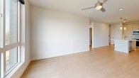 Located on East Colfax Avenue in Denver, Colorado, this modern 2-bedroom, 2-bathroom residence offers a thoughtfully designed single-floor layout with a clean, contemporary aesthetic throughout. Light-toned hardwood-style flooring flows seamlessly from room to room, complementing the neutral color palette that gives the space an open, airy feel.

The kitchen serves as a centerpiece, featuring flat-front cabinetry in a warm wood finish, quartz countertops, stainless steel appliances, a built-in wine cooler, a tiled backsplash, and a large central island with a sink — ideal for both meal prep and casual dining. Pendant lighting above the island adds a refined touch.

Both bedrooms are well-proportioned and filled with natural light from large windows with outdoor views of surrounding greenery. Ceiling fans are installed in each bedroom, and the primary bedroom includes direct balcony access. Two dedicated closets provide ample storage.

The bathrooms offer modern finishes, including light wood vanities with white quartz counters and undermount sinks. One bathroom features a glass-enclosed walk-in shower, while the second includes a soaking tub with full tile surround. Additional conveniences include an entrance foyer, hallway, pantry, and in-unit laundry room, rounding out this well-appointed Denver residence.