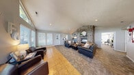 Located in Boise, Idaho, this single-floor clubhouse offers a thoughtfully designed community space that balances relaxation and fitness. The welcoming entrance opens into a sun-drenched lounge area featuring soaring vaulted ceilings and an expansive wall of large windows, flooding the space with natural light and providing views of the surrounding greenery. Warm tile flooring, leather armchairs, and tasteful décor create an inviting atmosphere for gathering or unwinding.

The adjacent living room serves as the heart of the clubhouse, anchored by a striking floor-to-ceiling stone fireplace with a mantle, complemented by vaulted ceilings and recessed lighting. Comfortable seating arranged around a central coffee table makes this an ideal spot for community members to socialize.

The two dedicated exercise rooms offer a comprehensive fitness experience. The main fitness area is spacious and well-lit, housing a range of cardio equipment including treadmills, stationary bikes, an elliptical, and a rowing machine, all arranged on protective floor mats. A second fitness room provides strength training options, featuring a multi-station cable machine, a weight bench, a full dumbbell rack, exercise balls, wall mirrors, and a ceiling fan for comfort. A water station is conveniently available for hydration. Together, these spaces deliver a complete community wellness facility.