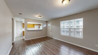 Located at 2111 Pretty Lake Ave in Norfolk, VA, this single-floor, 2-bedroom, 2-bathroom home offers a functional and straightforward layout. The living room serves as the heart of the home, featuring durable hardwood-style flooring, neutral-toned walls, and a large window that brings in natural light. A front entry door with a transom window adds a welcoming touch. The kitchen is designed in a galley style, equipped with warm honey-toned wood cabinetry, white appliances including a range, microwave, and refrigerator, and generous counter space. A pass-through window connects the kitchen to the living area, creating an open, interactive feel. The spacious primary bedroom features plush carpeting, a sliding-door closet, and connects conveniently to the hallway. The second bedroom also features carpet flooring and a window overlooking greenery, offering a comfortable and private retreat. Both bathrooms are clean and functional, with one featuring a tub-shower combo, tile flooring, and warm wood vanity with a stone-style countertop. A hallway with closet storage ties the layout together efficiently, making excellent use of the available square footage throughout this well-maintained Norfolk home.