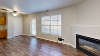 Located at Ravenwood Lane in Lafayette, Indiana, this one-bedroom, one-bathroom unit offers a well-organized single-floor layout with a functional mix of comfortable living spaces. The open living room serves as the heart of the unit, highlighted by a built-in fireplace, warm hardwood-style flooring, and a large window that allows natural light to fill the space. The entry foyer provides a clean transition into the main living area, continuing the same durable flooring underfoot. The kitchen is well-equipped with warm-toned oak cabinetry, ample upper and lower storage, white countertops, a double-basin sink, dishwasher, refrigerator, and a breakfast bar peninsula — ideal for both meal prep and casual dining. The bedroom features plush carpeting, a ceiling fan, and a generously sized window with an outdoor view, creating a restful retreat. A spacious walk-in closet with full wire shelving and hanging rods provides excellent storage capacity. The bathroom includes a single-sink vanity with oak cabinetry and a tub/shower combination, finished with hardwood-style flooring. The dedicated laundry room houses a full-size washer and water heater, adding everyday convenience to this thoughtfully laid-out home.