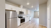 Located at 7995 NE Quatama St in Hillsboro, Oregon, this well-designed 2-bedroom, 2-bathroom residence offers a thoughtful single-floor layout with a clean, contemporary aesthetic. The open-concept living and kitchen area is bright and inviting, featuring light wood-look flooring, recessed lighting, and neutral wall tones that create a fresh, airy ambiance. Natural light streams in generously, casting warm patterns across the floors.

The kitchen is well-appointed with white shaker-style cabinetry, light quartz countertops, a stainless steel undermount sink, and a full suite of stainless steel appliances including a refrigerator, electric range, built-in microwave, and dishwasher — offering both style and functionality.

The bedrooms are carpeted for comfort, with the primary bedroom featuring a spacious closet with bi-fold doors. Both bathrooms include white cabinetry with quartz countertops, undermount sinks, and chrome fixtures. A hallway connects the private quarters to the main living areas, with a dedicated closet providing additional storage.

The second bedroom includes a wall-mounted HVAC unit and dual windows with blinds, offering views of the surrounding neighborhood. The overall design is modern and move-in ready, ideal for those seeking a comfortable, low-maintenance residence in the Hillsboro area.