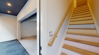 Located at 232 Gregory Ave in Passaic, NJ, this thoughtfully designed three-bedroom, three-bathroom unit spans three floors, offering a generous and well-organized layout. The ground level includes a private garage with concrete flooring and utility access, providing convenient and secure parking. The main living floor features an open-plan kitchen and living area flooded with natural light from large windows. The kitchen is outfitted with sleek, light wood flat-panel cabinetry, white quartz countertops, a tile backsplash, stainless steel appliances, and a matte black faucet — all contributing to a clean, contemporary aesthetic. Light hardwood flooring flows seamlessly throughout the living spaces and bedrooms, enhancing the bright and airy feel. Each bedroom is well-proportioned, with individual climate control units and windows offering natural light. The spacious primary bedroom includes a walk-in closet with built-in shelving and a view of surrounding greenery. The three bathrooms are distinctly finished — one features a glass-enclosed walk-in shower with vertical tile, a wall-mounted vanity, gold fixtures, and a backlit oval mirror, while another offers a soaking tub with sliding glass doors and terrazzo-style flooring. Staircase access connects all floors, with the overall design emphasizing modern finishes, functionality, and comfort throughout.