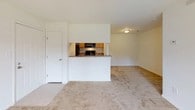 This single-floor residence offers a well-organized layout designed for comfortable everyday living. The main living area is carpeted and open, anchored by a pass-through kitchen that keeps the space connected and airy. The kitchen is equipped with black appliances including a range, over-the-range microwave, and refrigerator, complemented by warm wood cabinetry, granite-look countertops, and easy-care tile flooring.

The living room extends toward a wall of sliding glass doors that flood the space with natural light and provide direct access to an outdoor patio area, with pleasant green views beyond. A ceiling fan overhead adds both function and comfort.

The bedrooms are carpeted and well-lit, each featuring windows dressed with blinds. At least one bedroom includes a walk-in closet, offering generous storage. The neutral wall tones throughout create a clean, versatile backdrop.

Two full bathrooms serve the unit, each featuring a tub-shower combination with a curved curtain rod, toilet, and vanity. Brushed nickel fixtures lend a cohesive, contemporary finish to the bathrooms. Overall, the space presents a practical and comfortable layout with consistent finishes throughout.