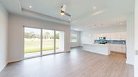 Located at 4003 Oleander Ave in Fort Pierce, FL, this modern single-story home offers four bedrooms and two bathrooms across a well-designed, open-concept floor plan. Light wood-look flooring runs throughout, complementing the crisp white walls and creating a clean, contemporary aesthetic.

The combined living and kitchen area serves as the heart of the home, highlighted by a tray ceiling with recessed lighting and a ceiling fan. Expansive sliding glass doors flood the space with natural light and open to views of the surrounding greenery. The kitchen features white shaker-style cabinetry, a striking teal subway tile backsplash, stainless steel appliances including a French door refrigerator and range, a pantry, and a central island with pendant lighting.

The spacious primary bedroom offers a generous footprint with high ceilings and easy access to additional rooms via well-connected hallways. Secondary bedrooms are bright and well-proportioned, each with light flooring and windows that bring in natural light.

The two bathrooms are finished with tile flooring and subway tile surrounds. One features a frameless sliding glass walk-in shower with a mosaic tile floor, while the other offers a full soaking tub with gold-tone fixtures. Both maintain a clean, spa-like quality throughout.
