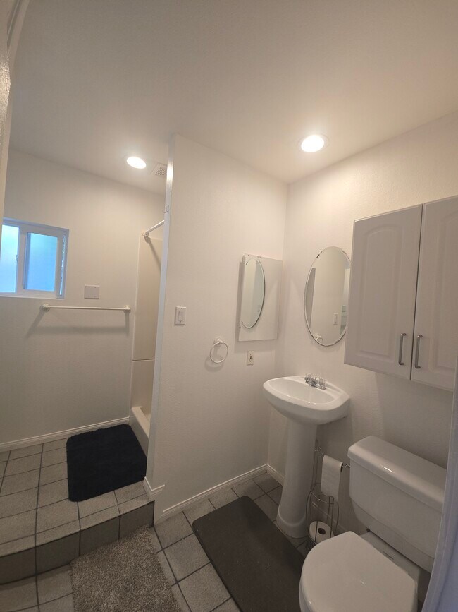 Baño con lavabo de pedestal, armario de almacenamiento y botiquín. - 7649 Beckett St