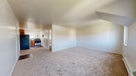 Located at 228 NY-376 in Hopewell Junction, NY, this one-bedroom, one-bathroom unit offers a practical and well-organized single-floor layout. The spacious living room features neutral wall-to-wall carpeting and an open sightline toward the kitchen, creating a cohesive and airy feel throughout the main living area. Multiple windows allow natural light to filter into the space, contributing to a bright and welcoming atmosphere.

The kitchen is equipped with warm wood-toned cabinetry, a stainless steel gas range, a refrigerator, and a mosaic tile backsplash that adds a touch of character. Hardwood-style flooring in the kitchen contrasts nicely with the carpeted living areas.

The bedroom is generously sized, featuring plush carpeting, a closet, and a window with views of the surrounding greenery. Baseboard heating is present throughout, ensuring year-round comfort. Three closets total provide ample storage across the unit.

The bathroom is finished with warm earth-toned ceramic tile surrounding a full soaking tub with a shower, complemented by a white vanity and tile flooring. A small window brings in natural light and ventilation. Overall, this unit offers a clean, functional living environment in a convenient Dutchess County location.