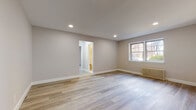 Located along Boulevard East in West New York, NJ, this thoughtfully renovated single-floor unit offers a clean, modern aesthetic throughout. Light wood-style plank flooring extends seamlessly across the living areas and bedrooms, complemented by neutral warm-gray walls and crisp white trim that create a bright, welcoming atmosphere.

The spacious main living area features recessed lighting and a classic cast-iron radiator, with windows that bring in natural light and views of the surrounding neighborhood. An open doorway connects the living space to the adjoining rooms, enhancing the sense of flow throughout the unit.

The kitchen is well-appointed with white cabinetry accented by gold hardware, a light-toned countertop, a blue-gray subway tile backsplash, and a stainless steel gas range. A window above the counter allows natural light to fill the space during meal preparation.

The bedrooms are generously proportioned, each featuring the same light flooring, neutral wall tones, and cast-iron radiators beneath windows that offer outdoor views. The bathroom is finished with white wall tiles, a full soaking tub with overhead shower, a floating vanity, and elegant marble-look floor tile, creating a clean and polished environment throughout.