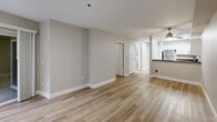 Located at 2226 Elliott Ave in Seattle, WA, this one-bedroom, one-bathroom residence offers a well-organized, single-floor layout with a clean, modern aesthetic throughout. Light wood-toned flooring runs seamlessly across every room, lending warmth and visual continuity to the space.

The kitchen features white cabinetry, dark countertops, a double-basin sink, and skylight panels overhead that invite natural brightness into the cooking area. It flows openly toward the hallway and living areas, creating an efficient and connected layout. Ample closet space is distributed throughout, with four closets providing generous storage options.

The living room is a standout feature, showcasing a classic fireplace framed by a white mantel and flanked by windows that draw in natural light and views of the surrounding neighborhood. Neutral warm-gray walls and light flooring keep the atmosphere open and inviting.

The bedroom is a comfortable, well-proportioned retreat equipped with a ceiling fan and a closet. The bathroom includes a full soaking tub with a tiled surround in a rich, dark speckled finish, accented by brushed nickel fixtures.

A private patio accessible via sliding glass doors adds valuable outdoor space. In-unit laundry and a dedicated entrance complete this thoughtfully arranged residence in the heart of Seattle.