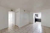 Located at 1570 Lane Ave S in Jacksonville, Florida, this single-story home offers four bedrooms and two bathrooms across a well-organized floor plan. The combined living and dining area is bright and open, finished with light ceramic tile flooring and a textured ceiling. A sliding glass door floods the space with natural light and provides direct access to the outdoor backyard area, offering a seamless indoor-outdoor connection.

The kitchen is a standout feature, outfitted with bold dark gray cabinetry, light stone-look countertops, a white subway tile backsplash, and black appliances including an electric range. Light tile flooring continues throughout the kitchen, which also benefits from a window that brings in additional natural light.

The four bedrooms are comfortably sized, with the primary bedroom being notably spacious. All bedrooms feature soft carpeting and louvered bi-fold closet doors, providing ample storage. The home includes five closets in total throughout the layout.

The two bathrooms are clean and functional. One features a tub-shower combo, single vanity, and tile flooring, while the second is a more compact bathroom with a walk-in shower. A dedicated utility room and a central hallway complete the efficient layout of this well-appointed Jacksonville home.