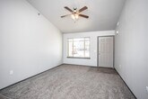 This two-floor home is thoughtfully designed with a functional open-concept layout that seamlessly connects the main living areas. The living room on the main level draws attention with its vaulted ceiling and ceiling fan, while natural light pours in through a front-facing window. Durable wood-look flooring flows through the main level, transitioning to plush carpet in the living and bedroom areas.

The kitchen is a standout feature, offering generous cabinetry in a rich dark finish, a central island, a double sink, and black appliances including a range, dishwasher, and microwave. A peninsula counter connects the kitchen to the living space, making it ideal for everyday living and entertaining. A staircase leads to the upper level from the kitchen area.

The bedrooms are carpeted and well-proportioned, each offering closet storage. The bathrooms are clean and modern, featuring wood-look tile flooring, dark vanity cabinetry with stone-look countertops, and a full tub-shower combination in the main bath. A convenient half bath is also present. A dedicated laundry closet houses a full-size washer and dryer with overhead shelving, adding everyday practicality to the space.