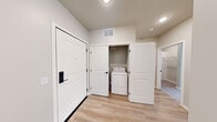 Located at 3600 Hoffman Rd in White Bear Lake, MN, this well-appointed single-floor home offers three bedrooms, two bathrooms, and three closets within a thoughtfully designed layout. The open-concept kitchen and living area serves as the heart of the home, featuring gray shaker-style cabinetry, a herringbone tile backsplash, white quartz countertops, stainless steel appliances, a center island, and pendant lighting. Light hardwood-style flooring flows throughout the main living areas, while a sliding glass door provides access to an outdoor balcony. The primary bathroom is equipped with a double-sink vanity, white quartz countertops, black hardware accents, a frameless glass walk-in shower, and light wood-tone flooring. The secondary bathroom offers a single vanity and a shower-tub combination. The bedrooms feature neutral carpet, large windows with blinds that invite natural light, and clean, neutral wall tones. A dedicated in-unit laundry closet with washer and dryer adds everyday convenience. Throughout the home, recessed lighting, black hardware details, and a consistent neutral color palette create a cohesive, modern aesthetic well-suited for comfortable living.