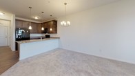 Located at 34011 Harvard Ave in Millsboro, Delaware, this single-floor residence offers a thoughtfully designed layout that balances comfort and practicality. The kitchen is a standout feature, showcasing rich dark cabinetry with ample storage, granite-style countertops, and a full suite of black appliances including a side-by-side refrigerator, electric range, and built-in microwave. Wood-look flooring grounds the kitchen and flows into the adjacent dining area, which is highlighted by an elegant chandelier and a peninsula counter that connects seamlessly to the living space, all finished with plush neutral carpeting. The bedrooms are generously proportioned, each featuring ceiling fans, soft carpeting, and windows with blinds that invite natural light while maintaining privacy. Two bathrooms serve the residence: one features a tub-shower combination, a dark-toned vanity, and wood-look flooring, while the other offers a walk-in glass-enclosed shower, a matching vanity, and the same warm flooring. A dedicated laundry area houses a full-size GE top-loading washer and dryer alongside wire shelving for added storage. Throughout the home, a neutral color palette and clean finishes create a bright, cohesive ambiance well-suited to a variety of lifestyles.