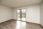 Located at 2020 Broadway St in Iowa City, Iowa, this two-bedroom, one-bathroom unit offers a practical and comfortable single-floor layout. The living area features light wood-look flooring and a textured ceiling, with a sliding glass door that opens onto a private balcony overlooking a green outdoor setting — bringing in natural light and a pleasant outdoor view. The kitchen is well-equipped with white cabinetry trimmed in warm wood tones, a gas range, dishwasher, refrigerator, and a built-in microwave, all finished in black appliances. A pass-through window connects the kitchen to the adjacent dining area, enhancing the open feel of the space. Both bedrooms are carpeted and include ceiling fans with light fixtures and windows that allow for natural light. The primary bedroom offers a double-door closet with built-in shelving for ample storage. The bathroom is clean and functional, featuring a full shower-tub combo and light wood-look flooring. A dedicated closet with wire shelving provides additional storage. In-unit laundry adds everyday convenience to this well-organized Iowa City residence.