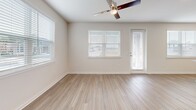 Located at 1320 Caprice Dr in Lakeland, FL, this two-story home offers 3 bedrooms, 3 bathrooms, and a well-organized layout spread across two floors. The main level houses the combined kitchen and living area alongside a full bathroom and an attached garage. The kitchen is a standout feature, boasting white shaker cabinetry, granite countertops, a central island with a sink, and stainless steel appliances including a range, microwave, and refrigerator. Light wood-style flooring runs throughout the main level, complementing the bright, neutral color palette. A staircase leads to the upper floor, where all three bedrooms are situated. The spacious primary bedroom features hardwood-style flooring and a ceiling fan, while the secondary bedrooms are finished with plush carpet and ceiling fans, offering a comfortable, cozy atmosphere. Each bedroom is paired with dedicated closet space, complete with wire shelving for practical storage. The three bathrooms are clean and modern, with one featuring a tiled tub-shower combo and granite vanity. A central hallway on the upper level connects all rooms efficiently. The attached garage offers ample space with a high ceiling and automatic opener.