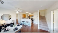 Located in Raleigh, NC, this two-story residence offers 4 bedrooms and 4 bathrooms spread across two thoughtfully designed floors. The main level features an open-concept layout where the living and dining areas flow seamlessly into the kitchen. Rich hardwood-style flooring anchors the space, while a ceiling fan overhead adds both function and character. The kitchen is equipped with warm wood cabinetry, stainless steel appliances, and a breakfast bar with seating — ideal for casual dining. A carpeted staircase connects the two levels. Each bedroom is comfortably sized with plush carpeting, generous natural light from large windows with blinds, and dedicated closet space. The primary bedroom features wide windows with exterior views and ample room for a full furniture arrangement. Additional bedrooms include workspace areas and stylish accent walls. Each of the four bathrooms offers a shower-tub combination in a clean, light-toned finish. The upper floor includes a secondary living area, providing a flexible lounge or study space. With four closets distributed throughout, this home offers practical storage alongside its functional and comfortable layout.