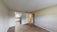 Located at 1225 Fairburn Rd in Atlanta, GA, this single-floor, 2-bedroom, 1-bathroom unit offers a practical and comfortable layout. The living room welcomes you with warm wood-look flooring, neutral taupe walls, a textured ceiling, and a window that brings in natural light — creating a bright, open feel.

The kitchen is well-appointed with crisp white cabinetry, a classic white subway tile backsplash, dark granite-style countertops, and a full suite of black appliances including a gas range, dishwasher, and refrigerator. A double-basin stainless steel sink sits beneath a window, and the wood-look flooring continues throughout.

Both bedrooms feature plush wall-to-wall carpeting, neutral walls, textured ceilings, and windows with blinds that allow natural light. Each bedroom includes closet access, providing functional storage. The primary bedroom offers a comfortable footprint with two doors — one leading to a closet and one to the hallway.

The bathroom is clean and functional, featuring a full tub-shower combination with white tile surround and a privacy window above. Throughout the unit, white trim and doors provide a consistent, tidy finish that ties each room together cohesively.