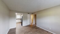 Located at 1225 Fairburn Rd in Atlanta, GA, this single-floor, 2-bedroom, 1-bathroom unit offers a practical and comfortable layout. The living room welcomes you with warm wood-look flooring, neutral taupe walls, a textured ceiling, and a window that brings in natural light — creating a bright, open feel.

The kitchen is well-appointed with crisp white cabinetry, a classic white subway tile backsplash, dark granite-style countertops, and a full suite of black appliances including a gas range, dishwasher, and refrigerator. A double-basin stainless steel sink sits beneath a window, and the wood-look flooring continues throughout.

Both bedrooms feature plush wall-to-wall carpeting, neutral walls, textured ceilings, and windows with blinds that allow natural light. Each bedroom includes closet access, providing functional storage. The primary bedroom offers a comfortable footprint with two doors — one leading to a closet and one to the hallway.

The bathroom is clean and functional, featuring a full tub-shower combination with white tile surround and a privacy window above. Throughout the unit, white trim and doors provide a consistent, tidy finish that ties each room together cohesively.