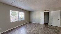 Located at 1600 Lansdowne Dr in Jacksonville, FL, this one-bedroom unit offers a practical and well-organized single-floor layout. Consistent wood-look flooring flows throughout the entire space, complemented by neutral gray walls and crisp white trim, creating a clean and cohesive aesthetic.

The galley-style kitchen is efficiently designed, featuring white shaker cabinets with modern bar-pull hardware, light countertops, a stainless steel sink, and black appliances including an electric range and refrigerator. A window provides natural light, while a hallway connects the kitchen directly to the rest of the unit.

The generously sized bedroom is one of the standout features of this space, offering ample room for furnishings. Two windows invite natural light and views of the surrounding greenery, fostering a bright and airy atmosphere. A dedicated closet with rod storage provides convenient organization, and a separate louvered-door closet adds additional storage flexibility.

Throughout the unit, textured ceilings and central HVAC vents are present in each room. The overall design is understated and move-in ready, with a functional simplicity that suits a variety of lifestyles. Clean white doors and bright baseboards add a polished finish to this well-maintained Jacksonville residence.