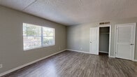 Located at 1600 Lansdowne Dr in Jacksonville, FL, this one-bedroom unit offers a practical and well-organized single-floor layout. Consistent wood-look flooring flows throughout the entire space, complemented by neutral gray walls and crisp white trim, creating a clean and cohesive aesthetic.

The galley-style kitchen is efficiently designed, featuring white shaker cabinets with modern bar-pull hardware, light countertops, a stainless steel sink, and black appliances including an electric range and refrigerator. A window provides natural light, while a hallway connects the kitchen directly to the rest of the unit.

The generously sized bedroom is one of the standout features of this space, offering ample room for furnishings. Two windows invite natural light and views of the surrounding greenery, fostering a bright and airy atmosphere. A dedicated closet with rod storage provides convenient organization, and a separate louvered-door closet adds additional storage flexibility.

Throughout the unit, textured ceilings and central HVAC vents are present in each room. The overall design is understated and move-in ready, with a functional simplicity that suits a variety of lifestyles. Clean white doors and bright baseboards add a polished finish to this well-maintained Jacksonville residence.