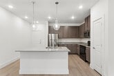 Located at 4770 Military Drive West in San Antonio, TX, this single-story, 3-bedroom, 2-bathroom home offers a well-designed layout with modern finishes throughout. Light-toned wood-style flooring flows seamlessly across every room, creating a cohesive and contemporary feel.

The open-concept kitchen and living area serve as the heart of the home. The kitchen is outfitted with rich, dark taupe shaker-style cabinetry, granite-look countertops, stainless steel appliances including a refrigerator and microwave, and a central island with pendant lighting and a built-in sink — ideal for both cooking and entertaining. Recessed lighting brightens the space throughout.

Each of the three bedrooms features neutral warm tones, ceiling fans with light fixtures, and windows with blinds that allow ample natural light. The primary bedroom includes its own en-suite bath with a dual-sink vanity, dark cabinetry, granite countertops, a walk-in shower, and direct access to a walk-in closet. The secondary bathroom mirrors this design with a dual-sink vanity and generous storage. Additional closets throughout the home provide practical storage solutions. The overall ambiance is clean, bright, and move-in ready.